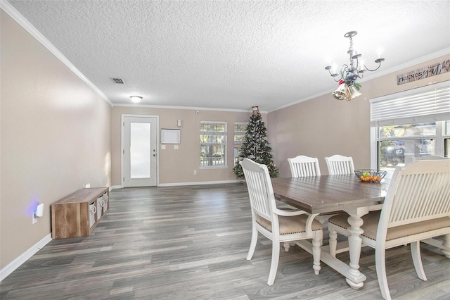 dining space featuring a notable chandelier, dark hardwood / wood-style flooring, a textured ceiling, and ornamental molding