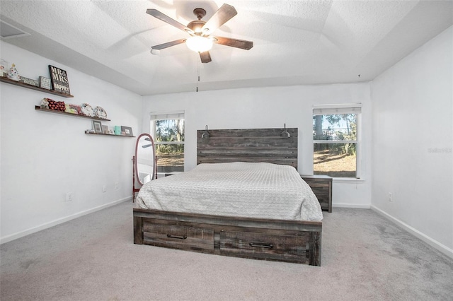 carpeted bedroom with ceiling fan and a textured ceiling