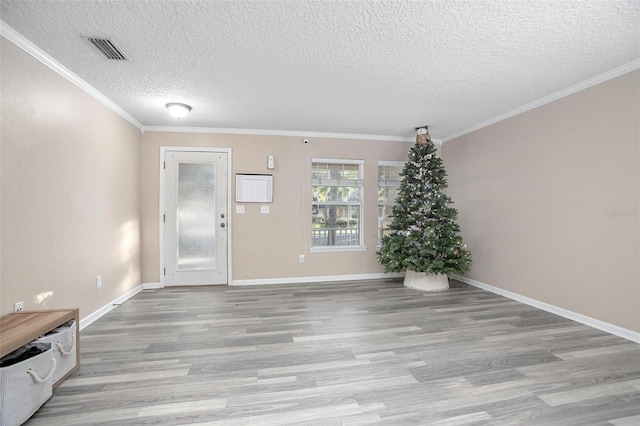 entrance foyer featuring light hardwood / wood-style floors, a textured ceiling, and ornamental molding