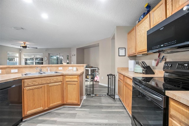 kitchen with black appliances, sink, light hardwood / wood-style flooring, ceiling fan, and a textured ceiling