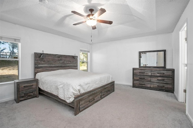 bedroom with multiple windows, ceiling fan, and light colored carpet