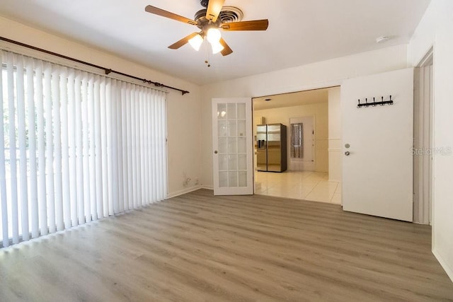 empty room featuring ceiling fan, french doors, and wood-type flooring