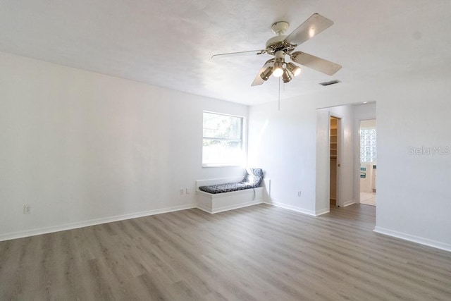 empty room with ceiling fan and wood-type flooring