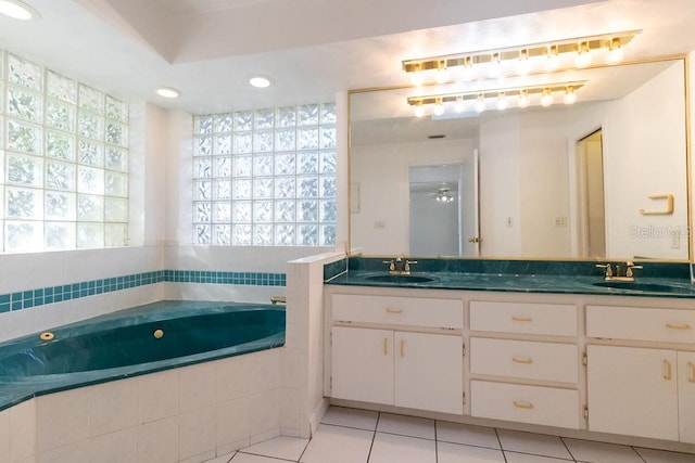 bathroom featuring tiled tub, tile patterned flooring, and vanity