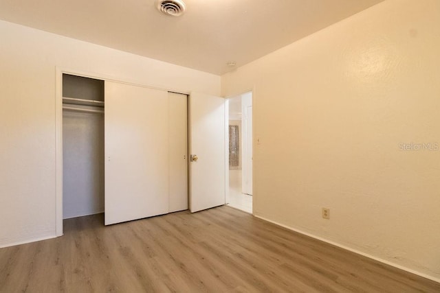 1068 N St, Daytona Beach, FL 32114 - unfurnished bedroom with wood finished floors, a closet, and baseboards