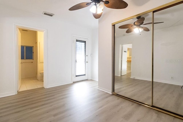 1068 N St, Daytona Beach, FL 32114 - unfurnished bedroom featuring wood finished floors, connected bathroom, and baseboards