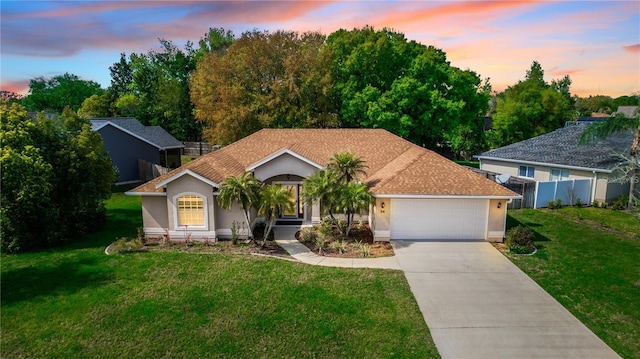 view of front of property with a garage and a yard