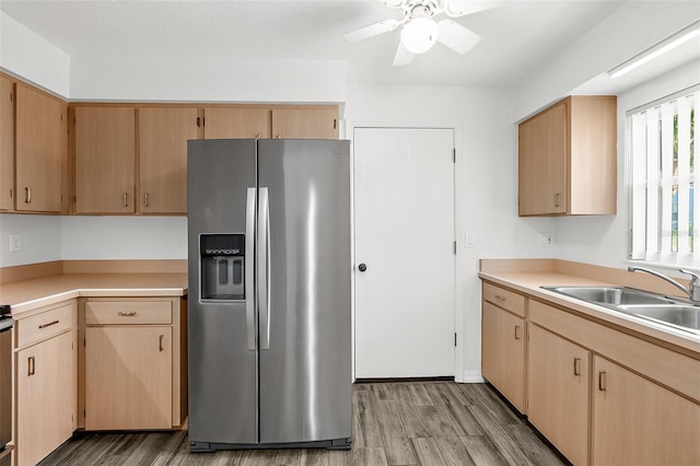 kitchen with light brown cabinets, sink, light hardwood / wood-style flooring, ceiling fan, and stainless steel fridge