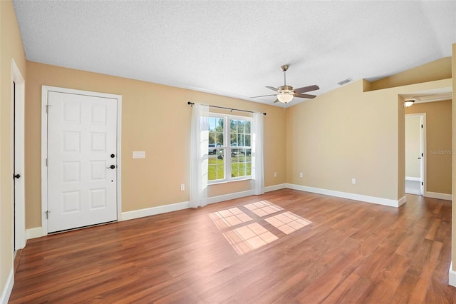 interior space featuring hardwood / wood-style floors, ceiling fan, lofted ceiling, and a textured ceiling