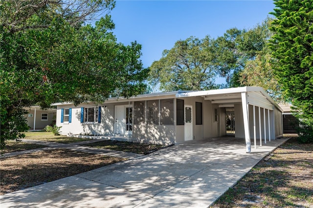 view of front of house featuring a sunroom and a carport