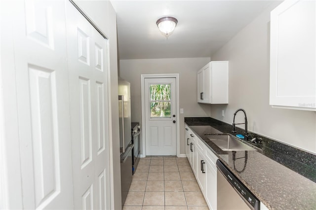 kitchen featuring white cabinetry, sink, stainless steel dishwasher, dark stone counters, and light tile patterned floors