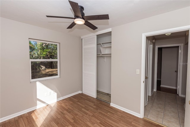 unfurnished bedroom featuring wood-type flooring, a closet, and ceiling fan