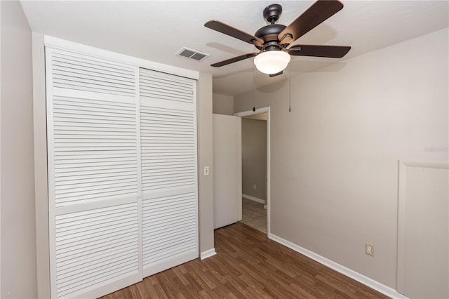 unfurnished bedroom featuring ceiling fan, dark wood-type flooring, and a closet