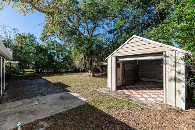 view of yard with a patio area, a garage, and an outdoor structure