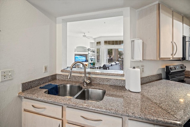 kitchen with stone counters, ceiling fan, sink, and electric range oven