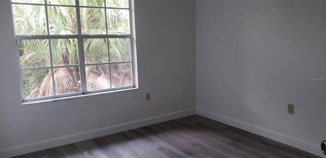 unfurnished room with dark hardwood / wood-style floors and a wealth of natural light