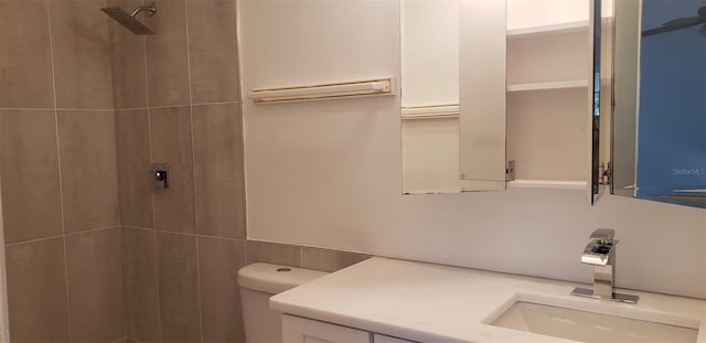 bathroom featuring vanity, toilet, and tiled shower