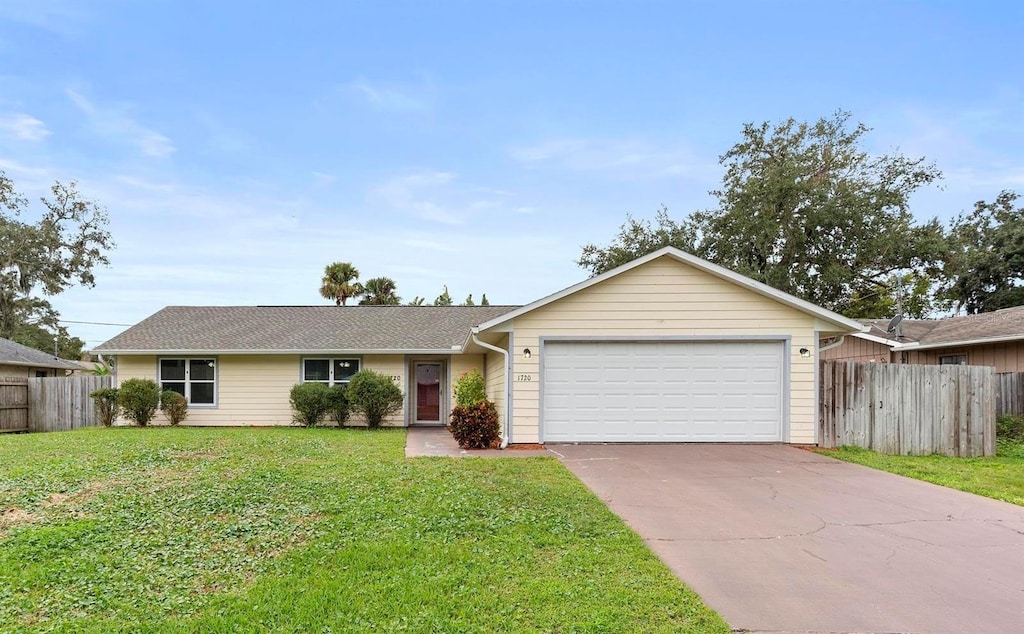 ranch-style house featuring a garage and a front yard