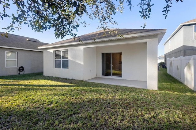 back of house with a lawn and a patio area