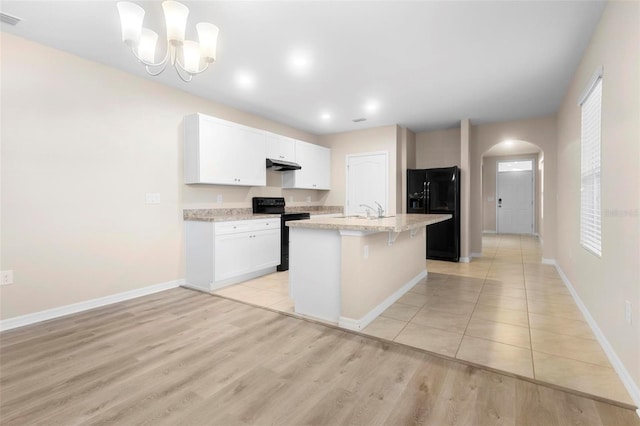 kitchen featuring white cabinetry, decorative light fixtures, an island with sink, and black appliances