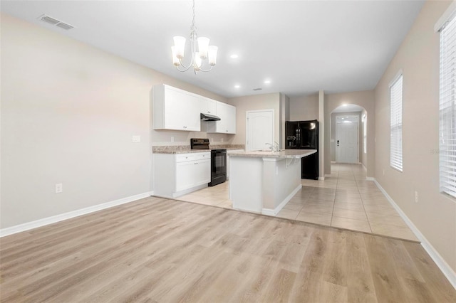 kitchen featuring black appliances, light hardwood / wood-style flooring, hanging light fixtures, a kitchen island with sink, and white cabinets