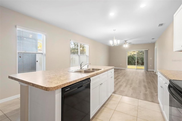 kitchen featuring sink, a kitchen island with sink, hanging light fixtures, black appliances, and white cabinets