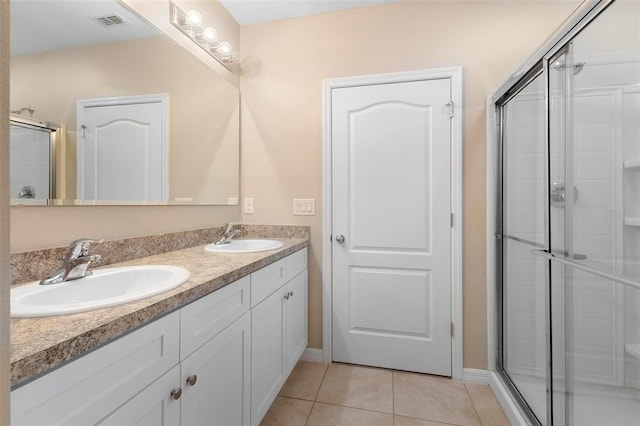 bathroom featuring a shower with door, vanity, and tile patterned floors