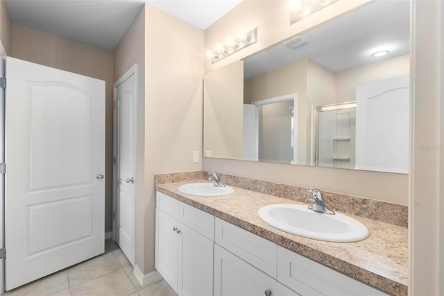 bathroom with vanity, a shower with door, and tile patterned flooring