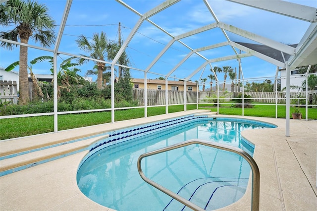 view of swimming pool featuring a lanai, a lawn, and a patio area