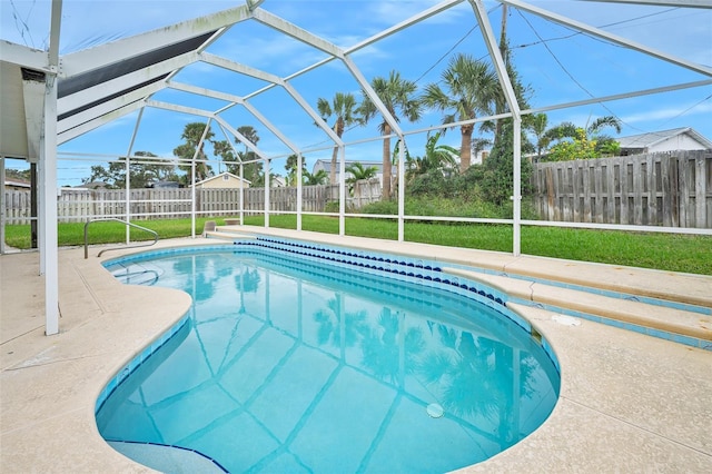 view of swimming pool featuring a patio area, glass enclosure, and a lawn