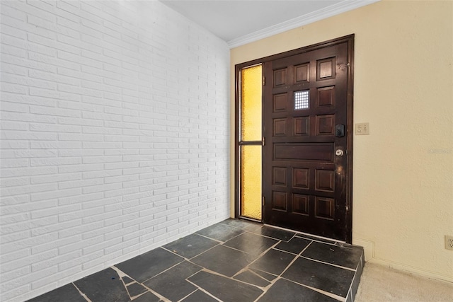 entryway featuring crown molding and brick wall