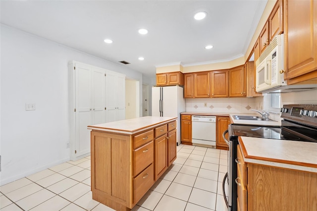 kitchen featuring tasteful backsplash, sink, a center island, light tile patterned floors, and white appliances