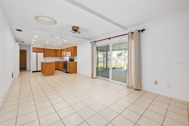 kitchen featuring white appliances, a center island, light tile patterned floors, ceiling fan, and beam ceiling