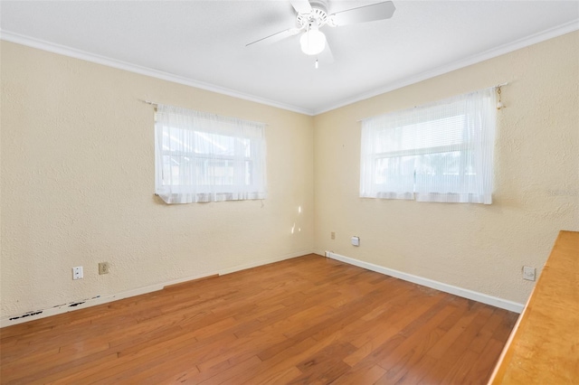 spare room with hardwood / wood-style flooring, ornamental molding, plenty of natural light, and ceiling fan