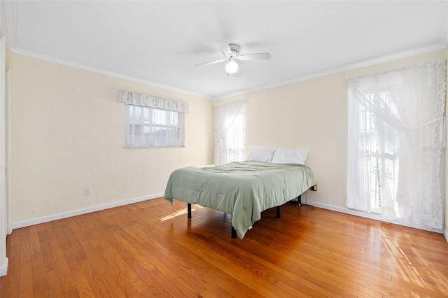 bedroom with hardwood / wood-style flooring, ceiling fan, and crown molding