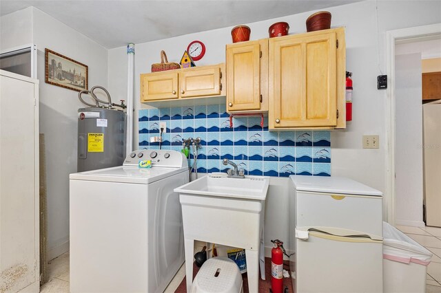 laundry area featuring water heater, light tile patterned floors, washer / dryer, and cabinets