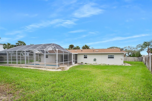 rear view of property with a fenced in pool, a lanai, and a lawn