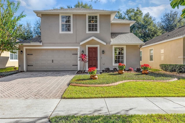 view of property with a front yard and a garage