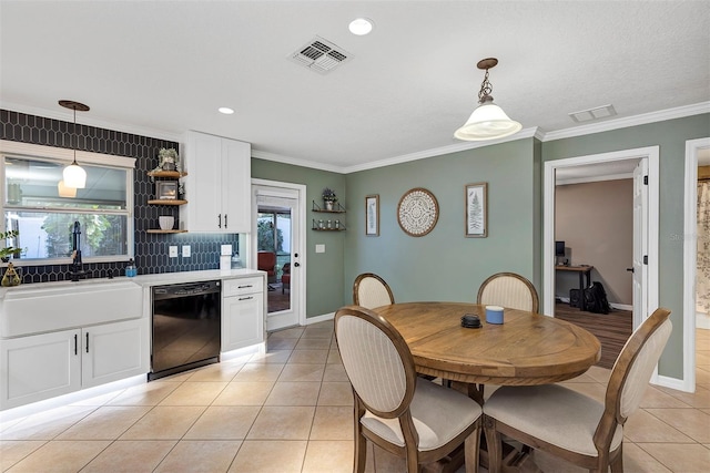 dining space with light tile patterned flooring, crown molding, and sink