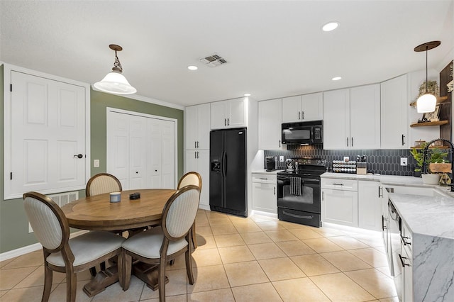 kitchen featuring sink, decorative light fixtures, white cabinetry, and black appliances