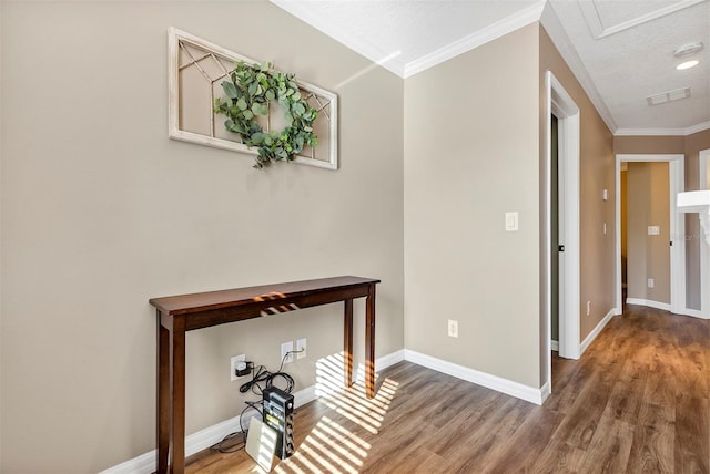 hall with wood-type flooring, a textured ceiling, and ornamental molding