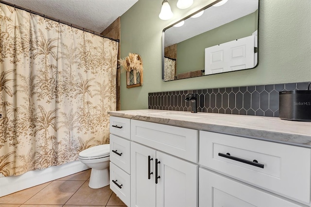 bathroom with tile patterned flooring, a textured ceiling, toilet, decorative backsplash, and vanity