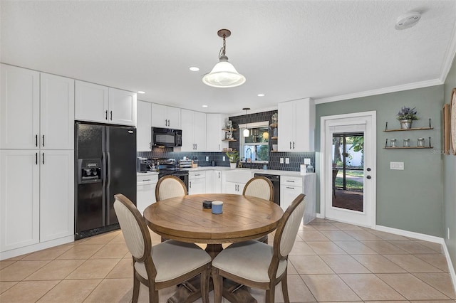 tiled dining room featuring crown molding, sink, and a textured ceiling