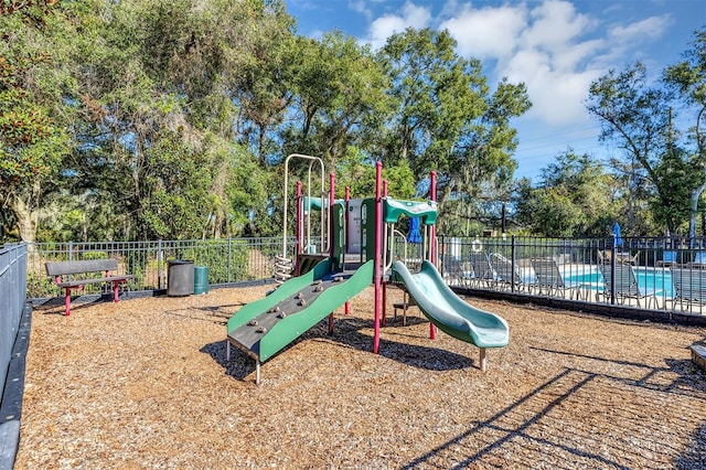 view of jungle gym with a community pool