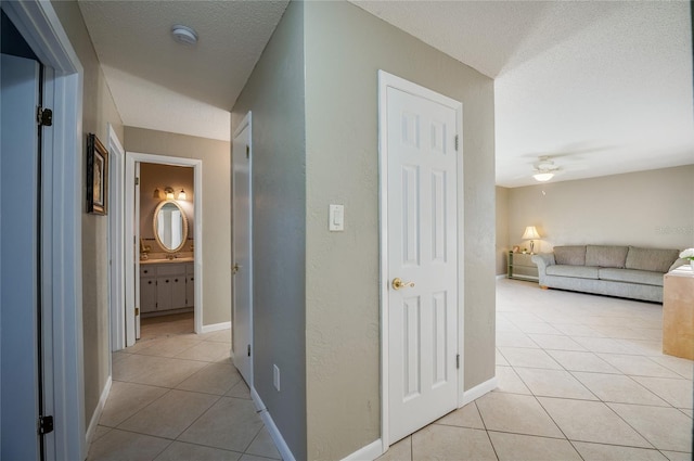 hallway featuring a textured ceiling and light tile patterned floors