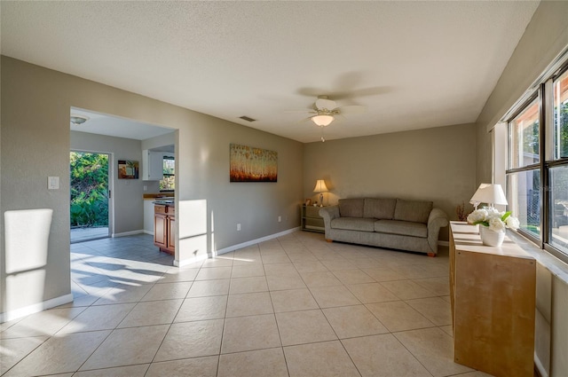 tiled living room featuring a textured ceiling and ceiling fan