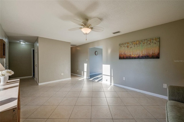 tiled spare room featuring ceiling fan and a textured ceiling