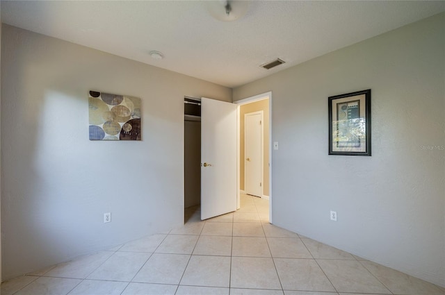 unfurnished bedroom featuring a textured ceiling and light tile patterned floors