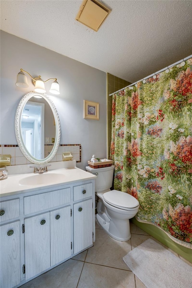 bathroom with toilet, vanity, tasteful backsplash, tile patterned floors, and a textured ceiling