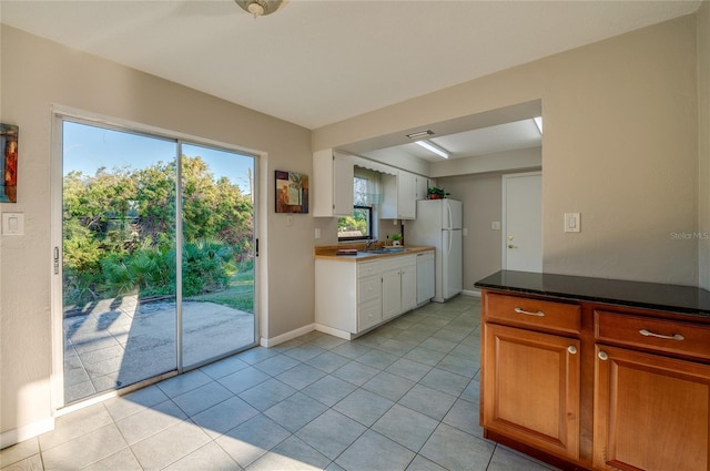 kitchen with sink, white appliances, and light tile patterned flooring